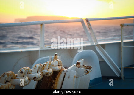 Lasciando Mgarr a Gozo su Gozo Channel Company traghetto per Malta. Catena di ancoraggio, tramonto, pacifico modo di viaggiare Foto Stock