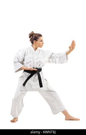 Lunghezza piena ripresa di profilo di una ragazza di karate facendo un kata isolati su sfondo bianco Foto Stock