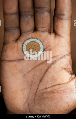 100 ruandesi franc moneta nella mano di un abitante di un villaggio. Foto Stock