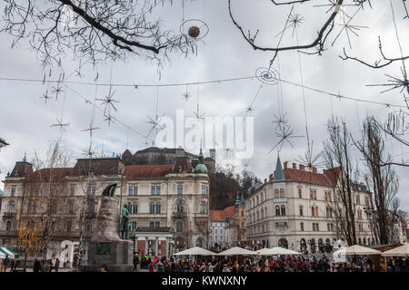 LJUBLJANA, Slovenia - 16 dicembre 2017: Folla riunita per il mercatino di Natale in Piazza Presernov con Tromostovje ponte e castello di Ljubljana in b Foto Stock