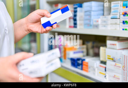 Il farmacista azienda Scatola per medicine in farmacia farmacia. Foto Stock