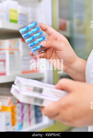 Il farmacista azienda casella di medicina e la capsula pack in farmacia farmacia. Foto Stock