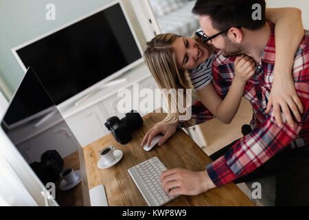 Attraente di giovani progettisti che lavorano insieme da casa Foto Stock