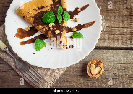 Pancake con cioccolato e i dadi a forma di cuore. Concetto di alimentare il giorno di San Valentino Foto Stock
