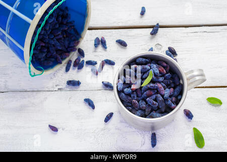 Ancora in vita, cibo e bevande concetto. Caprifoglio gli acini in una tazza Foto Stock