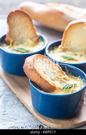 Ciotole di zuppa di cipolla sul pannello di legno Foto Stock