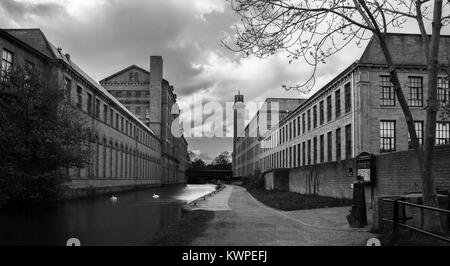 Monocromatico. Salts Mill in Saltaire, un sito del patrimonio mondiale nel West Yorkshire. La Leeds Liverpool canale scorre tra gli edifici. Foto Stock