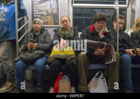 La gente ride a casa dal lavoro in una New York City metropolitana treno durante la serata Rush Hour. Foto Stock