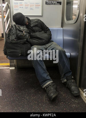 Stanco uomo dorme in una New York City metropolitana treno. Foto Stock