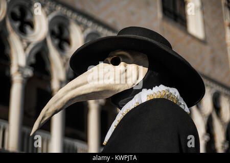 Medico della Peste maschera veneziana tradizionale costume di carnevale di Venezia, con Palazzo Ducale decorazione gotica in background Foto Stock