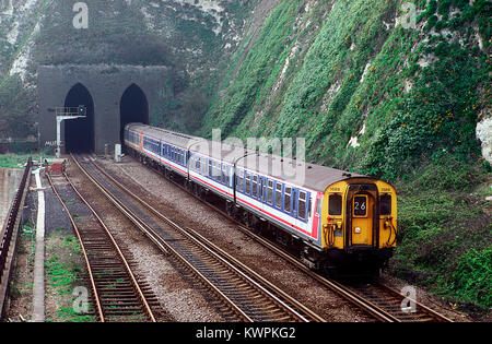 Una coppia di rete di classe a sud-est 411 4 CEP EMU numeri 1588 e 1567 emergono da Shakespeare Cliff tunnel tra Dover e Folkestone. Dal 8 aprile 1993. Foto Stock