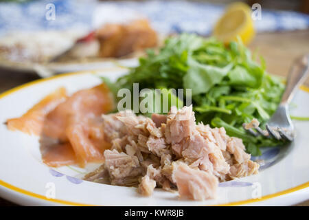 Conserve di tonno in olio di oliva servito con insalata verde Foto Stock