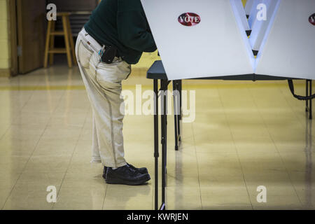 Milano, Iowa, USA. 4 apr, 2017. Un elettore getta il suo voto a Sant'Ambrogio chiesa cattolica centro parrocchiale in Milano Martedì, 4 aprile 2017. Come di 2:00 la posizione di polling aveva ricevuto 49 scrutini dagli elettori. Credito: Andy Abeyta, Quad-City volte/Quad-City volte/ZUMA filo/Alamy Live News Foto Stock