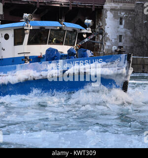 Un rimorchiatore che lavora per rompere il ghiaccio sul fiume per tenerlo aperto al traffico commerciale nel centro di Chicago come gennaio temperature tuffo. Foto Stock