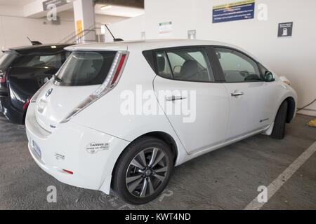 La Nissan Leaf plug-in veicolo elettrico, con California aria limpida decalcomania Veicolo visibile, collegato alla presa di corrente e la ricarica in San Francisco, California, 29 settembre 2017. () Foto Stock