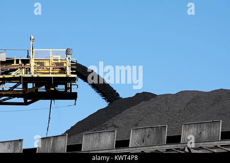 Il giallo del carbone nastro trasportatore che trasportano carbone e versare su un palo Foto Stock