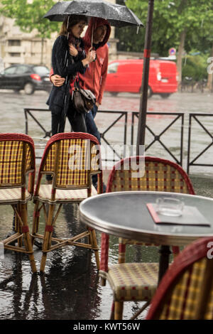 Francia, Parigi, giovane camminando sotto la pioggia. Foto Stock