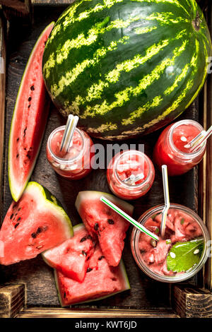 Cocktail di freschi Cocomeri di bottiglie. Su uno sfondo di legno. Foto Stock