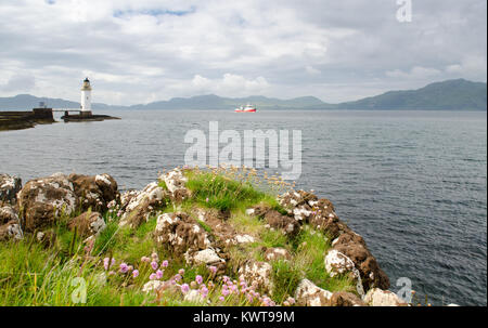 Barche di passare il faro di Rubha nan Gall sulla spiaggia rocciosa di Scozia Isle of Mull. Foto Stock