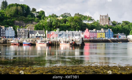 Tobermory, Scotland, Regno Unito - 21 Giugno 2014: barche da pesca una ormeggiata nel porto accanto al famoso dipinto luminosamente case di Tobermory village lungomare Foto Stock