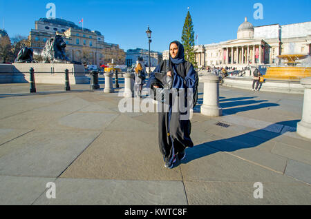 Londra, Inghilterra, Regno Unito. Donna asiatica in abiti neri e hijab, Trafalgar Square Foto Stock