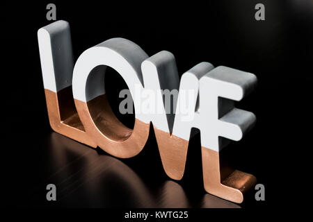 Due tonalità 'amore' riflettendo su tavoli in legno nero Foto Stock