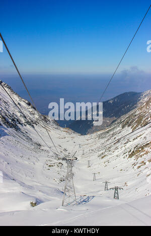 Auto linee via cavo che passa al di sopra della famosa strada Transfagarasan, coperto di neve Foto Stock