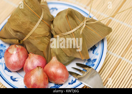 Tradizionalmente il riso avvolto gnocchi di patate e cipolle sulla piastra. Foto Stock
