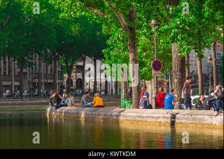 Parigi Canal Saint Martin, su una molla tarda sera lungo gli argini del Canal Saint-Martin nel centro di Parigi i giovani rilassarsi e socializzare. Foto Stock