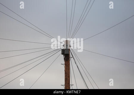 I cavi telefonici fanning fuori da un palo del telegrafo Foto Stock