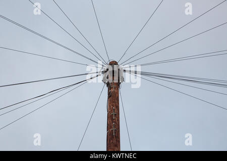 I cavi telefonici fanning fuori da un palo del telegrafo Foto Stock