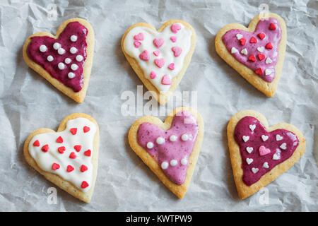 A forma di cuore i cookie da vicino per il giorno di San Valentino - festa in casa decorata buiscuits pasticceria i cookie su carta da forno, Valentino amore concetto Foto Stock