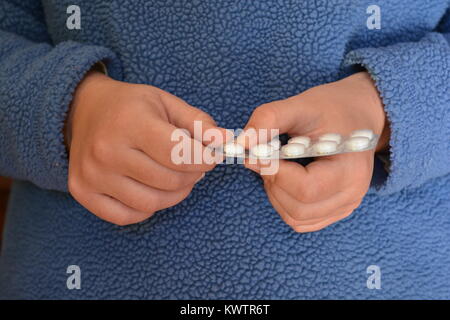 Assistenza sanitaria e farmaci. Donna di prendere una compressa al di fuori di un blister. Foto Stock