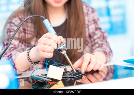 Schoolgirl in robot di laboratorio microcontrollore di debug Foto Stock