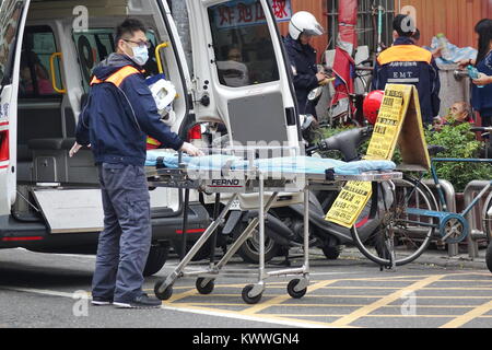 KAOHSIUNG, Taiwan -- dicembre 31, 2017: una emergenza medica team si prepara a caricare un vecchio uomo che è il senso di malessere in un anbulance. Foto Stock