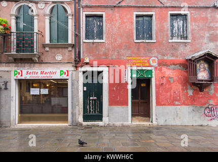 PD Partito Democratico e il Partito Comunista Italiano uffici fianco a fianco con un effigi con una pittura votiva di Gesù Cristo e nel centro di Venezia, Italia Foto Stock