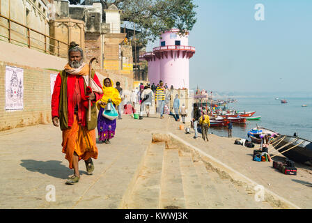 Indiano santo uomo a camminare lungo il fiume Gange, Varanasi, India Foto Stock