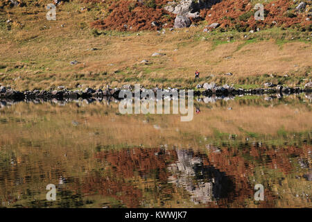 Pendio di montagna si riflette nelle calme acque del lago, nella contea di Kerry, Irlanda Foto Stock