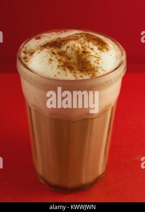 Delizioso cappuccino in un vetro trasparente, coperto con cannella Foto Stock