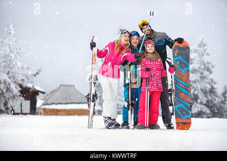 La famiglia felice tenendo selfie foto durante lo sci nella neve Foto Stock