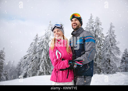 Coppia sorridente felice insieme sulla montagna per le vacanze invernali Foto Stock