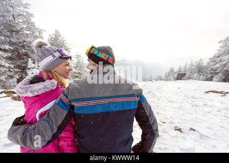 Donna e uomo in amore su vacanze inverno insieme sul terreno di sci, vista posteriore Foto Stock