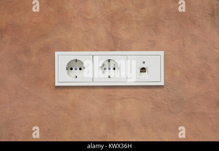 Doppie moderne prese elettriche e la linea di rete. Marrone chiaro parete in stucco sullo sfondo. Closeup, dettagli. Foto Stock