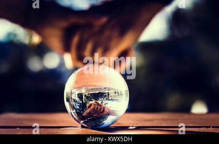 Riflessi di mani legate nella sfera di cristallo Foto Stock