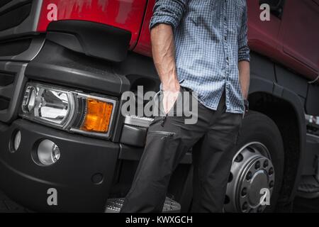 Semi Camionista lavoro. Caucasian Trucker davanti al Suo carrello. Primo piano. Foto Stock