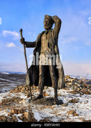 KURKUT MONTAGNA, Regione di Irkutsk, Russia - 4 Marzo 2017: statua in bronzo di Transbaikalian tramp. Un viaggiatore scalzi in piedi su un aspetto di tubercolo int Foto Stock