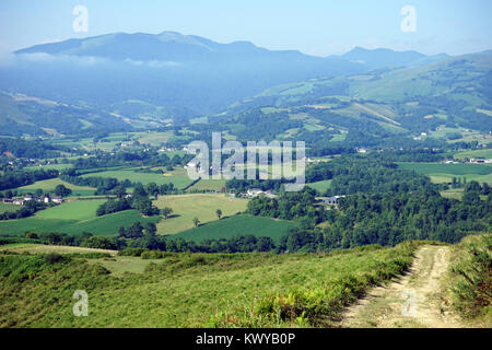 Road, villaggio e colline in Pyrenee Foto Stock