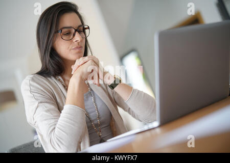 Donna che lavorano da casa su computer portatile Foto Stock