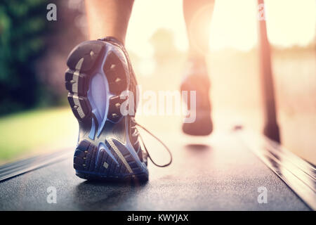 Uomo che corre in una palestra su un tapis roulant nozione di esercizio, fitness e uno stile di vita sano Foto Stock