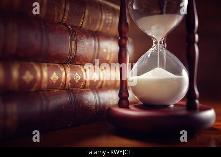 Libri antichi e clessidra in llibrary Foto Stock